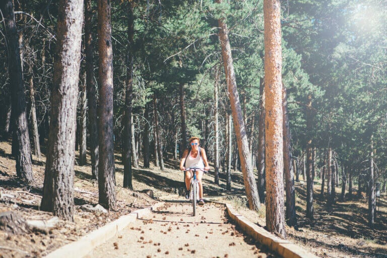 Woman riding her bicycle through a forest