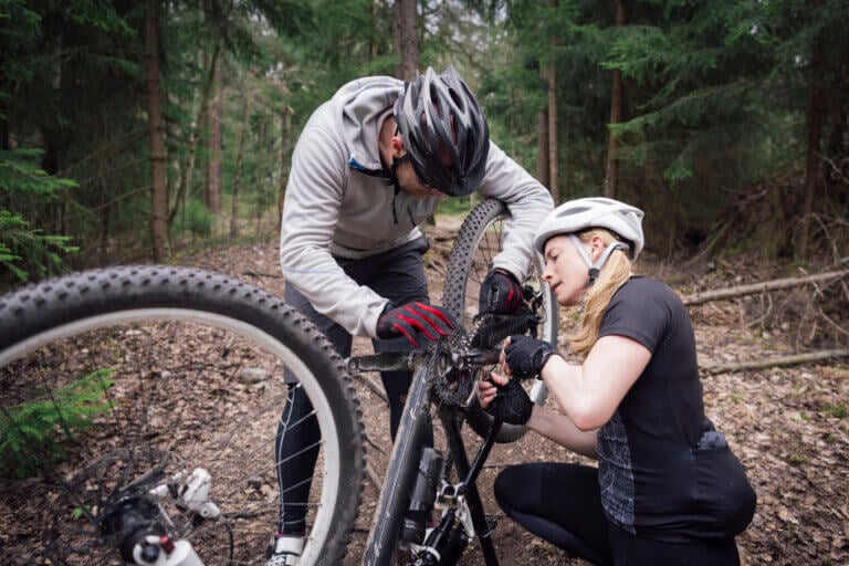 Man and woman repairing flat bicycle tire