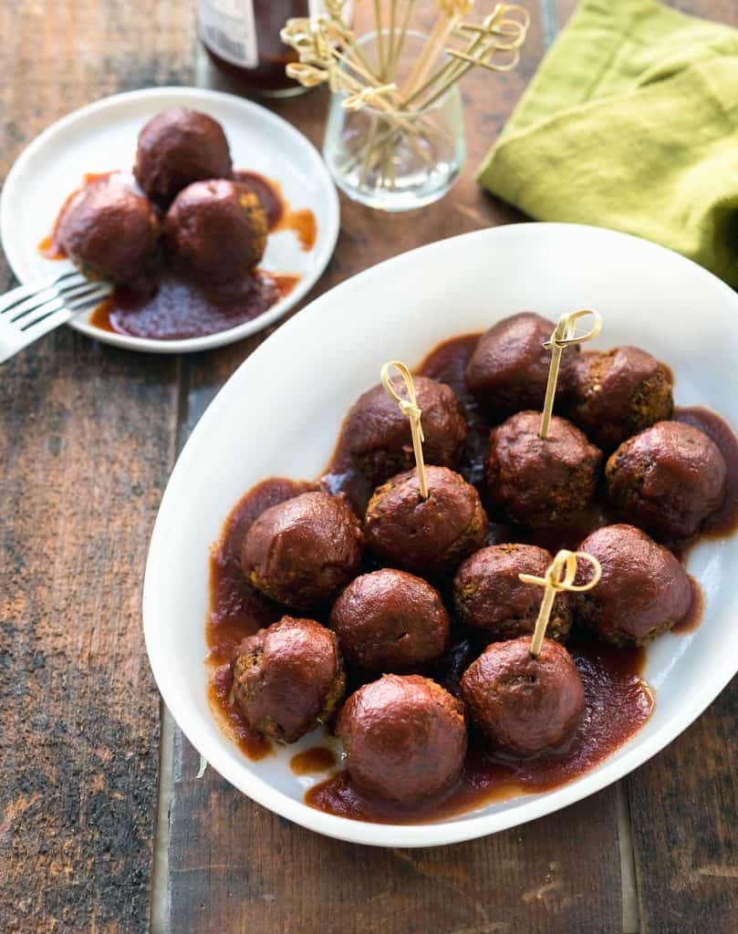 Image of lentil meatballs covered in barbecue sauce in a white dish
