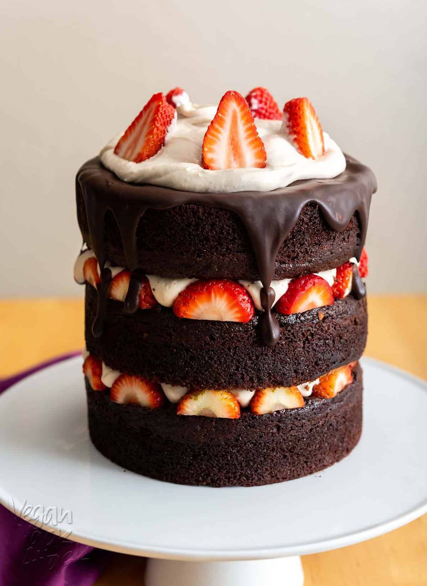 Image of chocolate layer cake with strawberries and vanilla mousse on a white cake stand