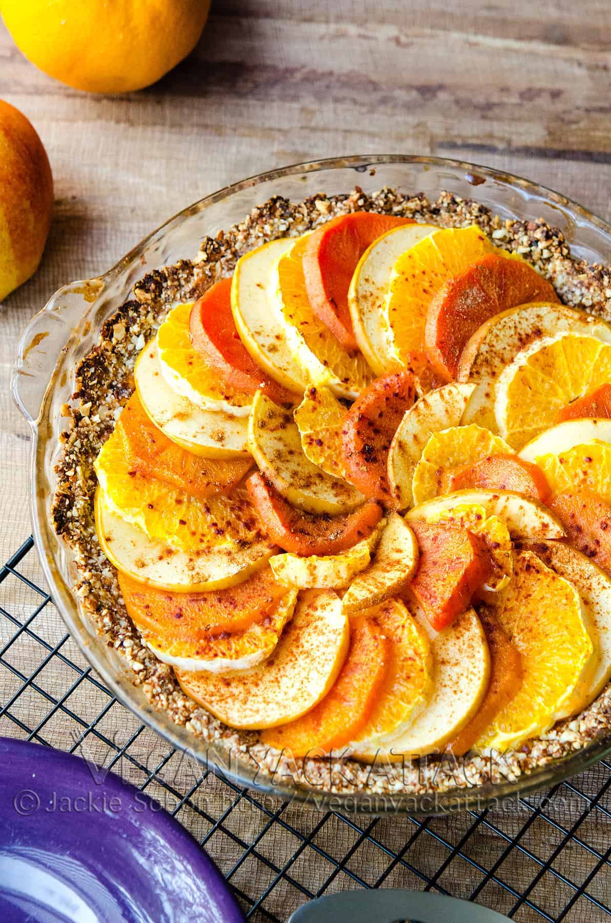 Layered fruit tart in a glass pie dish on a cooling rack