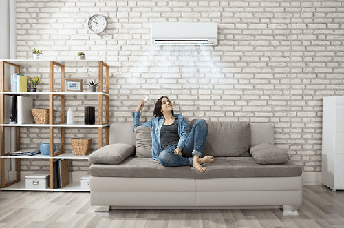 a woman enjoys air conditioning inside her home on her couch