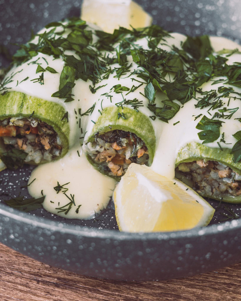 Gefüllte Zucchini mit weißer Zitronensoße und frischen Kräutern