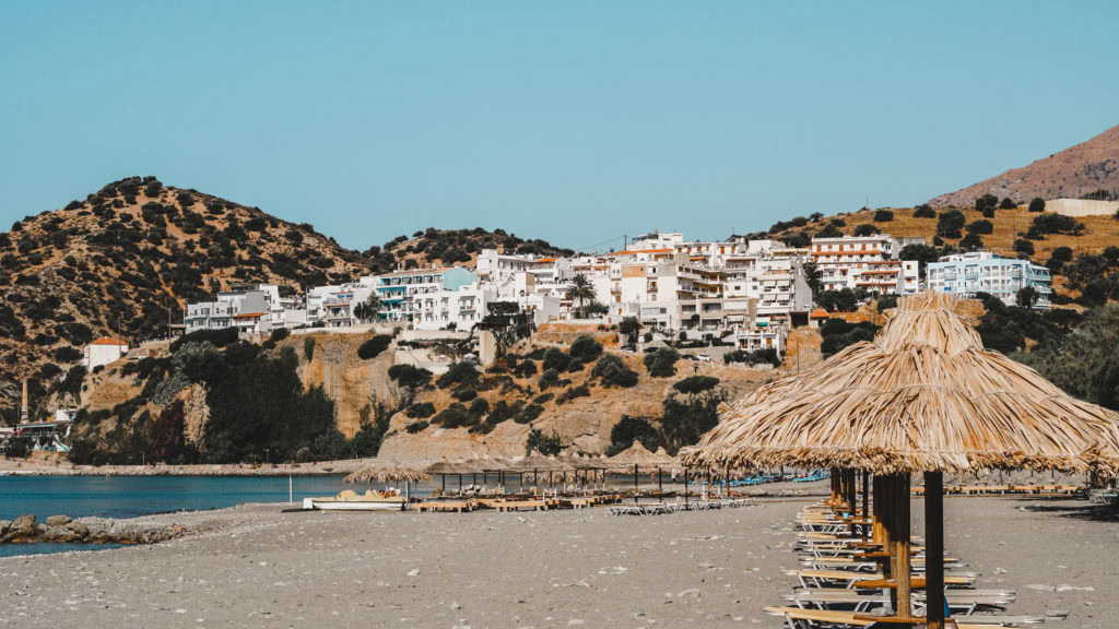 Agia Galini Strand auf Kreta mi weißen Häusern im Hintergrund