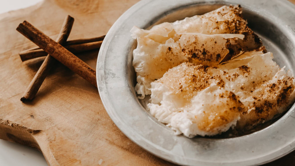 Bougatsa mit Zimt und Zucker auf einem Holzbrett