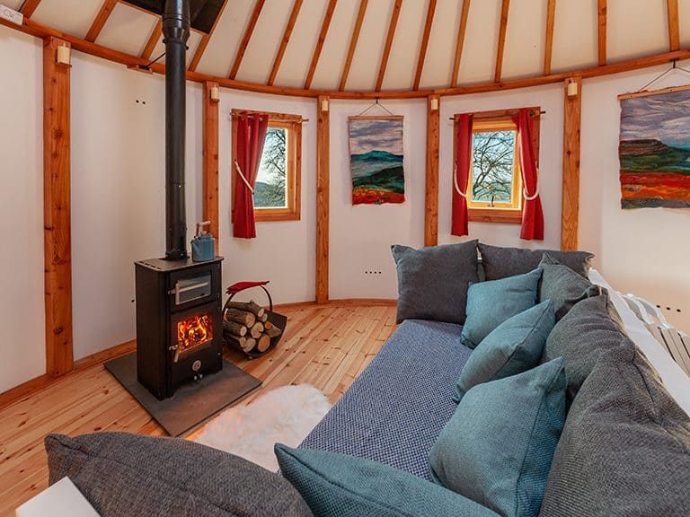The wood-burning stove (with inbuilt oven!) & living area of Kelker Well Roundhouse