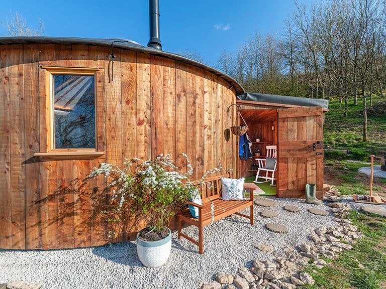 The exterior and porch area (complete with rocking chair!) of the Kelker Well Roundhouse, in northern England