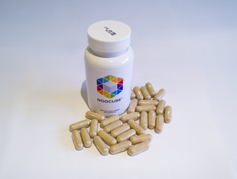bottle of NooCube supplements with capsules around it