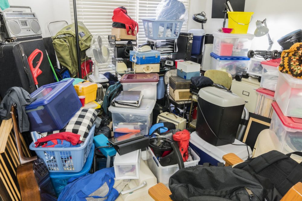 Hoarder room packed with stored boxes, electronics, files, business equipment and household items.