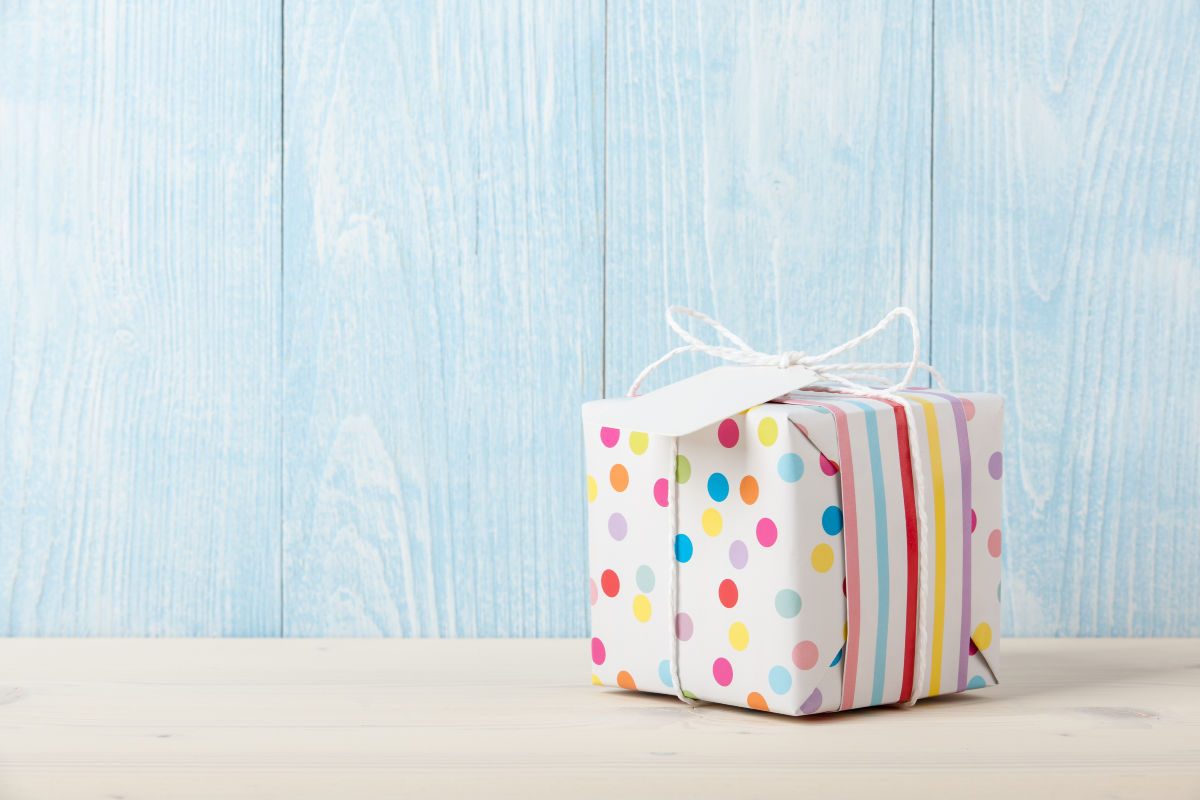 gift ideas for kids- single wrapped gift on a table with a blue wooden background
