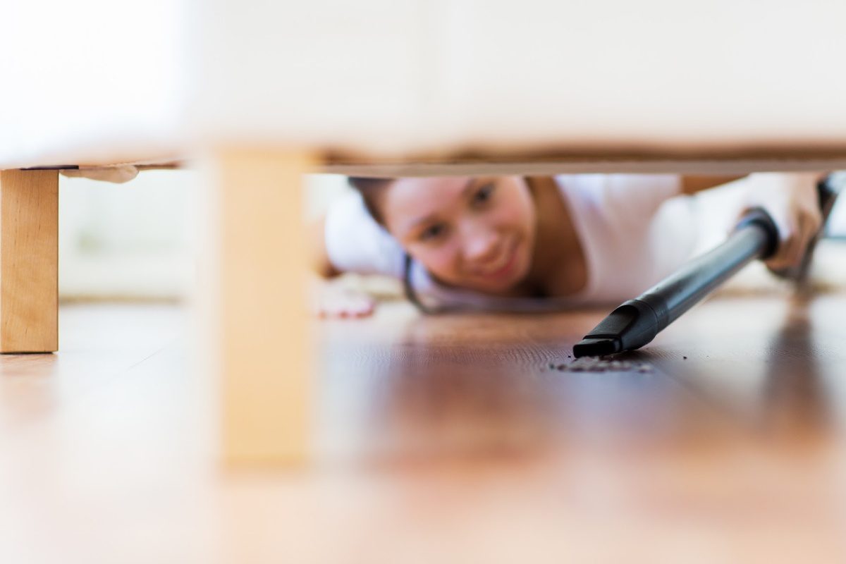 Things you forget to clean-woman vacuuming under couch