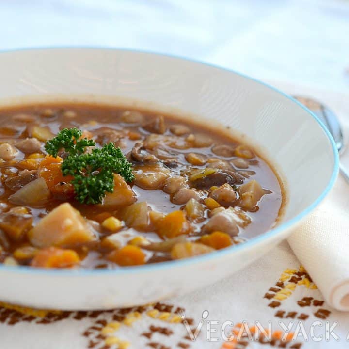 Smoky mushroom vegetable soup in a large bowl, topped with parsley