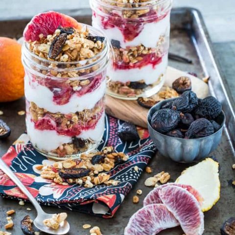 Vanilla Almond Fig Granola Parfaits with Blood Oranges in two jars on a baking sheet