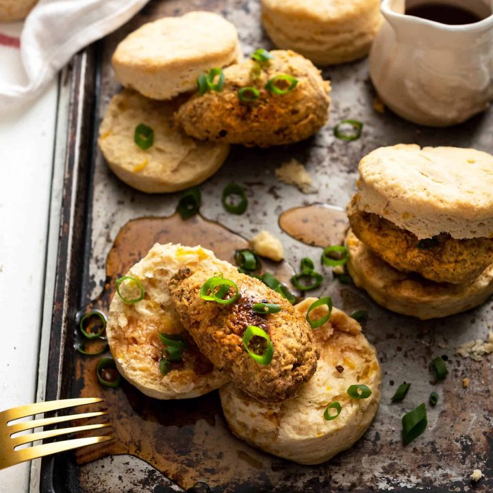 Image of vegan sourdough biscuits topped with homemade chicken wings, on a baking sheet.