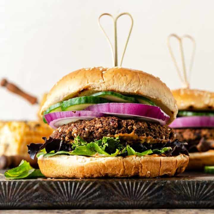 Grilled eggplant burger stacked with onion, cucumbers, mixed greens and bun