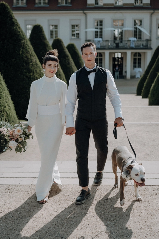 Hochzeitsfotograf Brautpaar mit Hund an der hochzeitslocation