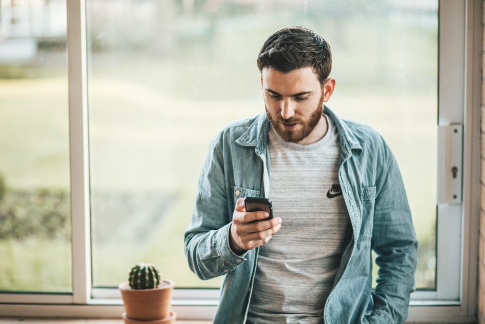 Man reading automated text message - OnSpot Social App