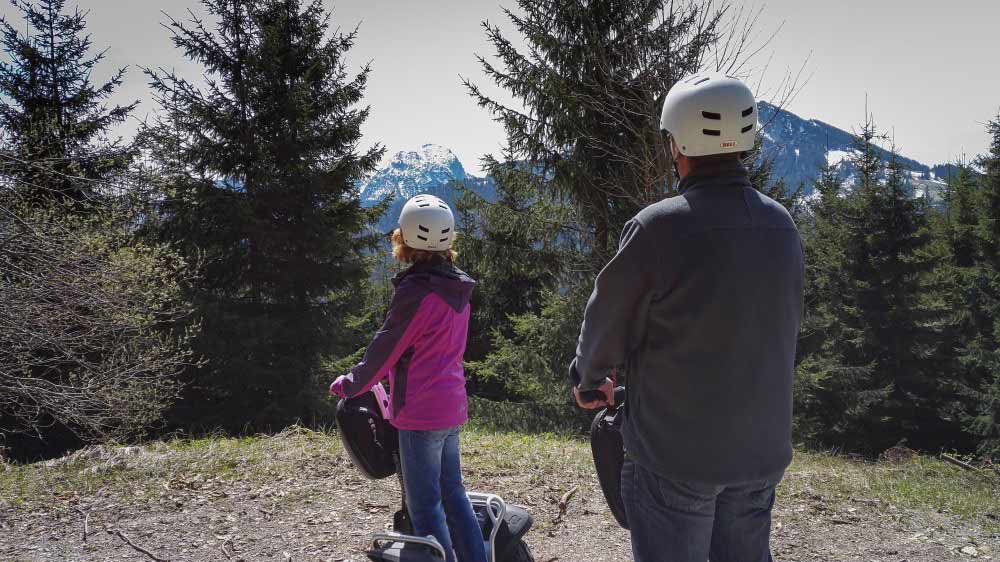 zwei Segway Fahrer auf Tour und sehen zum schneebedeckten Wendelstein
