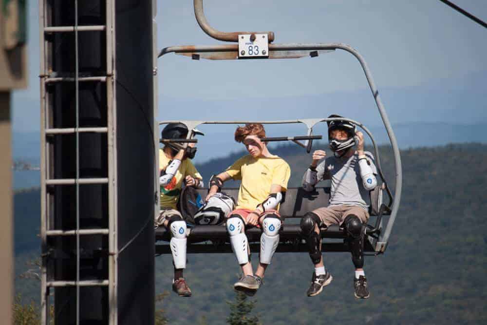 Three guys riding the lift up to the top of Mount Snow in Vermont.