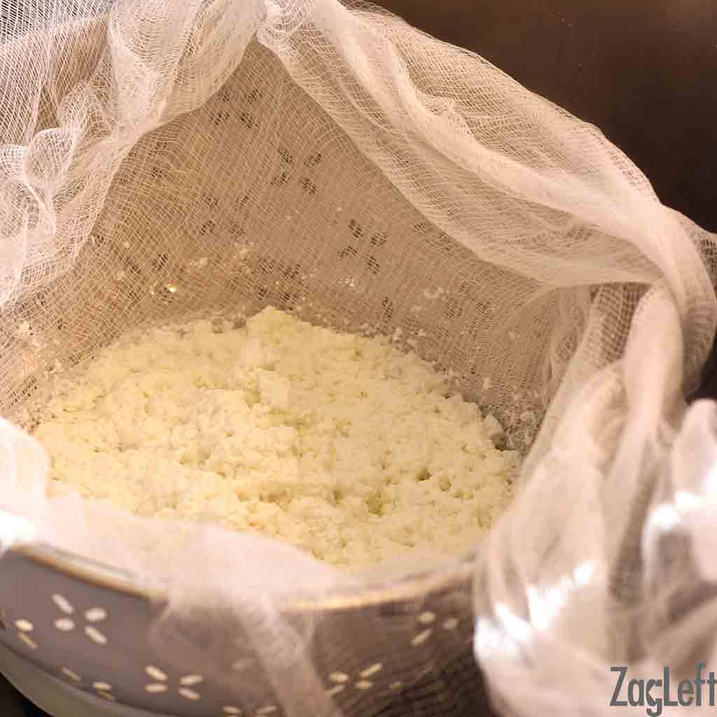 Paneer in colander lined with a cheesecloth