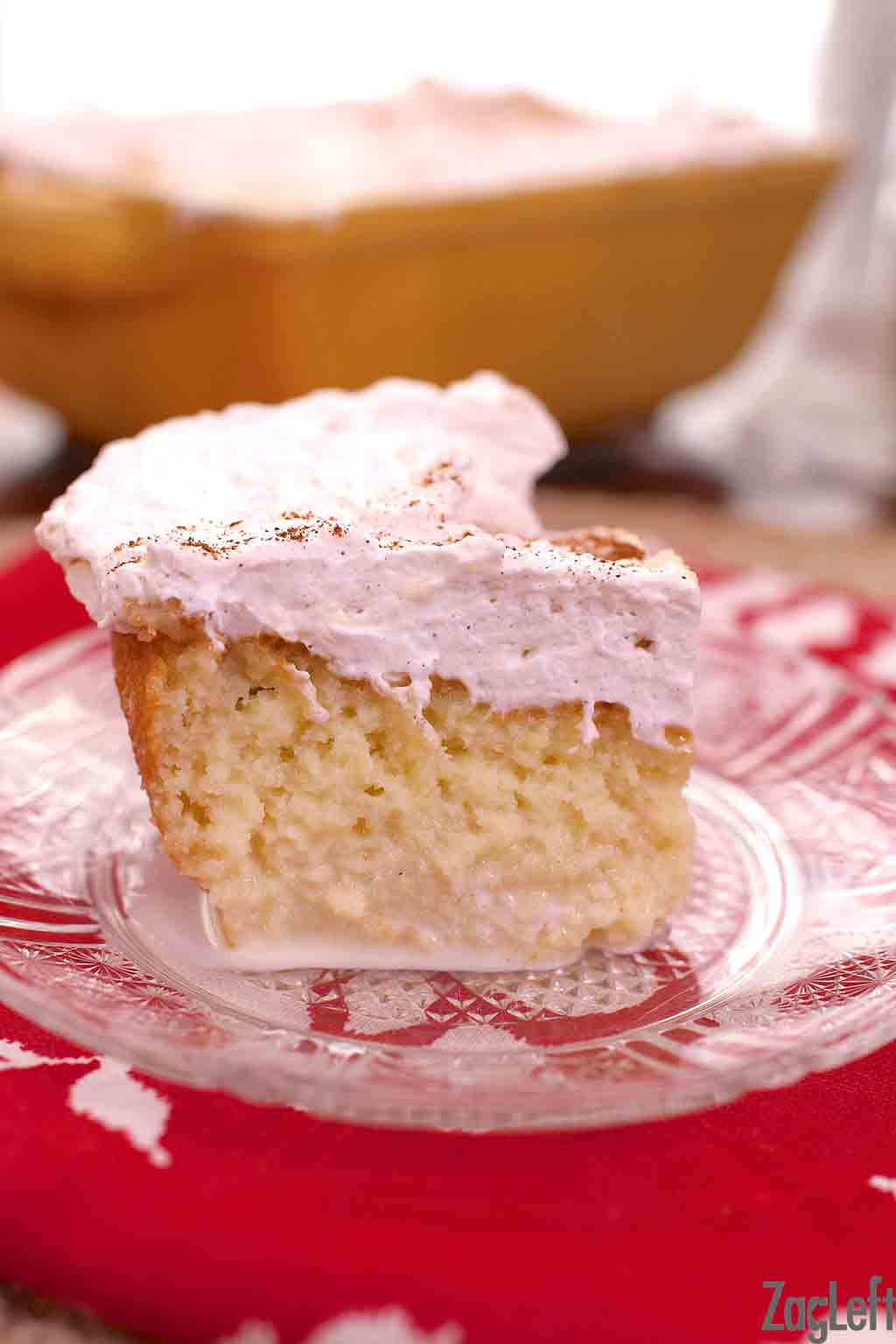Square slice of tres leches cake on a small plate