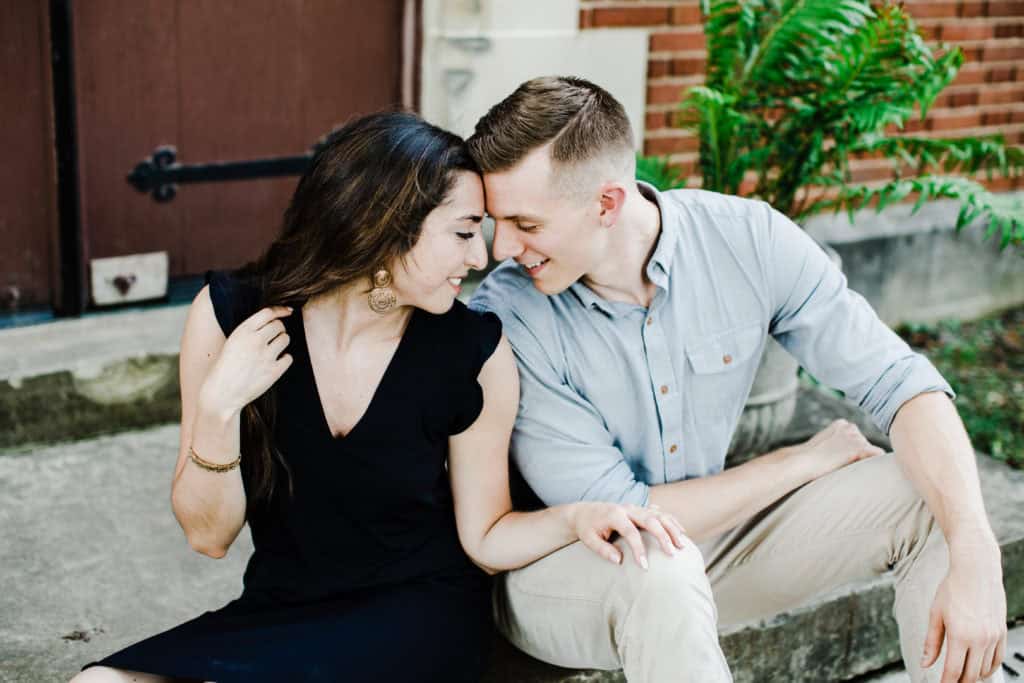 engagement session couple sitting on the stairs and touching their foreheads