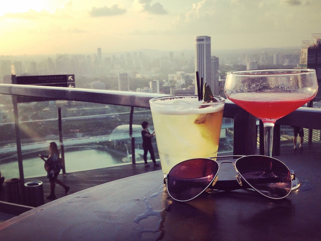 Zwei Alleinreisende genießen zusammen Cocktails in Singapur