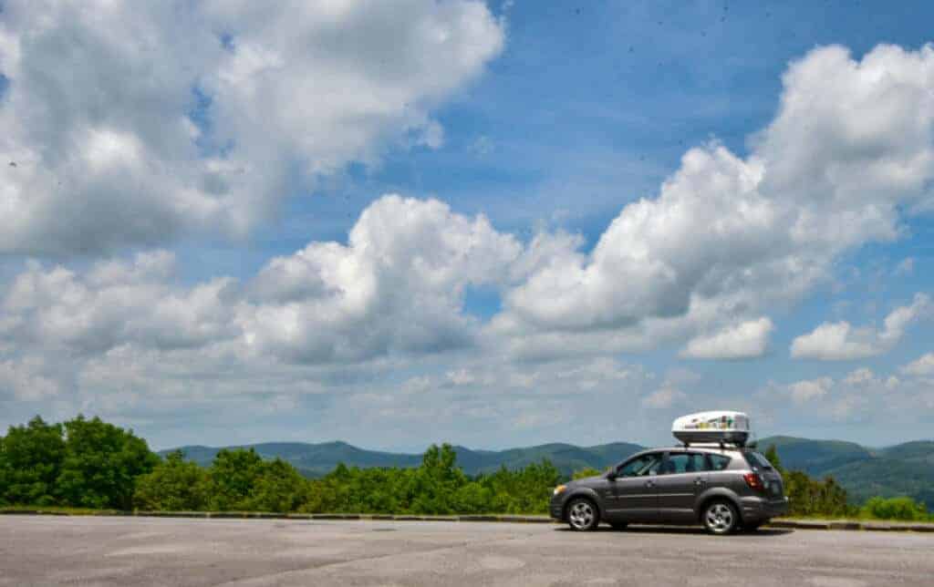 A small grey car parked at an overlook on the Blue Ridge Parkway in Virginia.