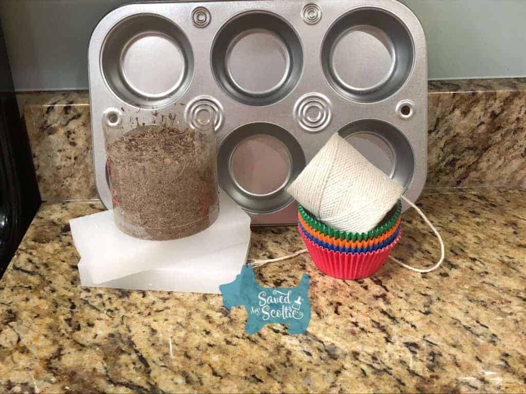 supplies needed for diy firestarters muffin tin, wood shavings, paraffin wax, cupcake liners and cotton string, arranged on a granite countertop
