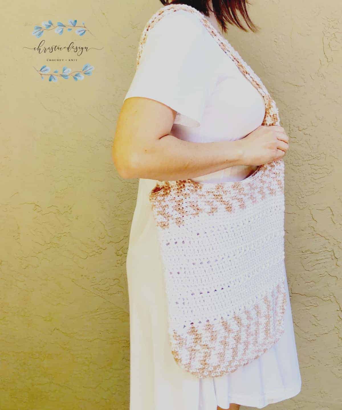 picture of woman in white turned to side with crochet book bag on shoulder