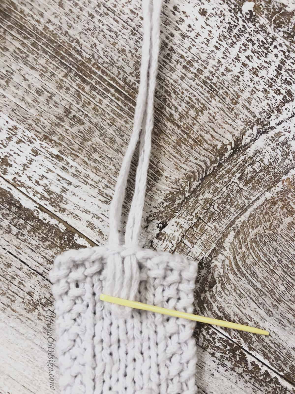 picture of yellow yarn needle threaded with white fringe for knit bookmark