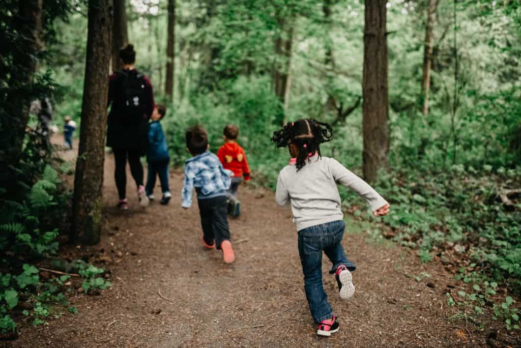 Young children run down a hiking path.