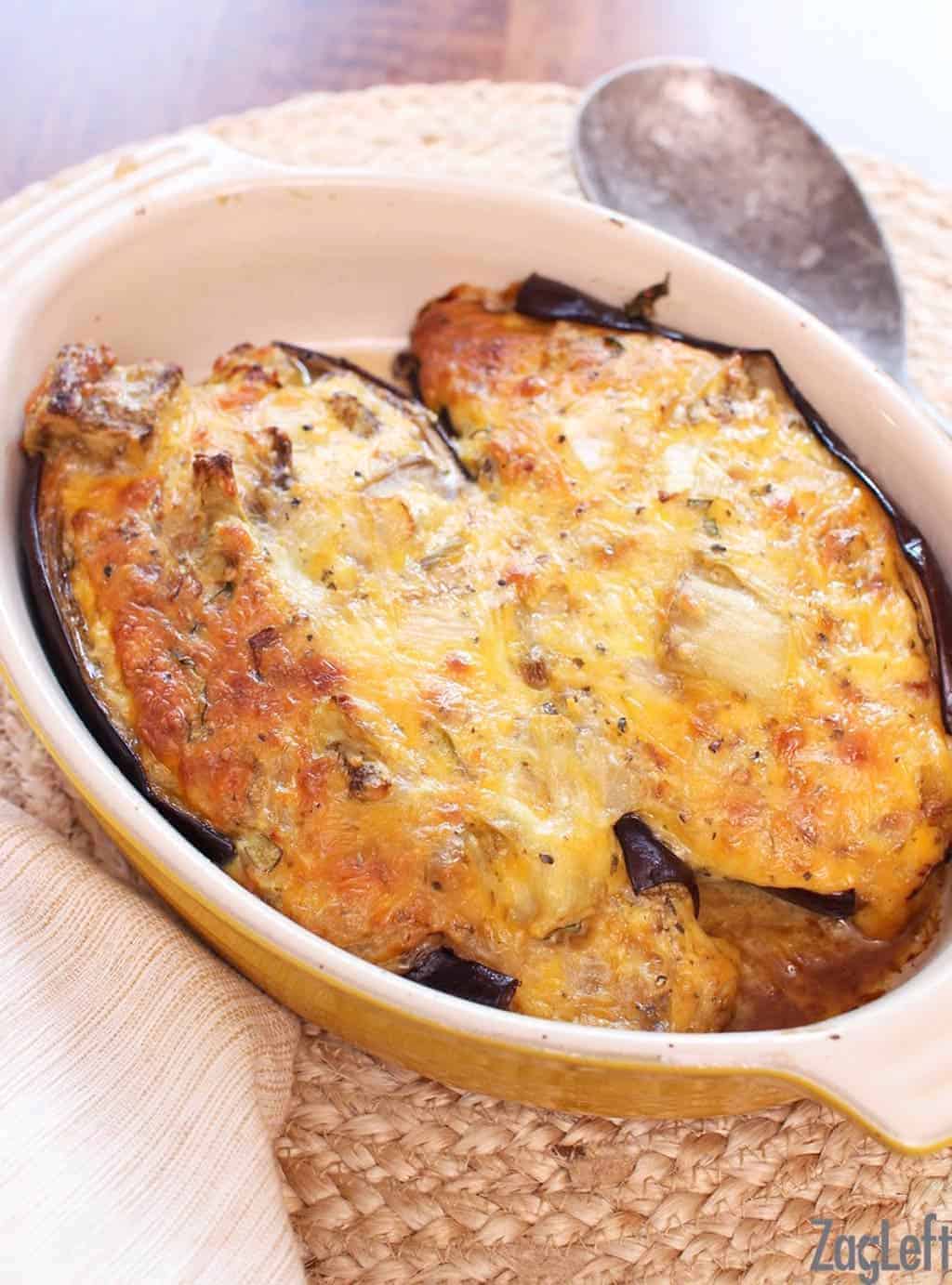 Two halves of twice baked eggplant in a cooking dish