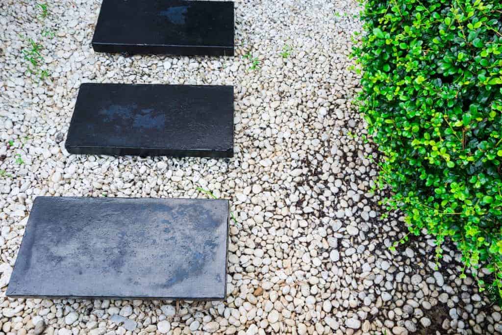 Pebbles surrounding and supporting slate stepping stones along a path