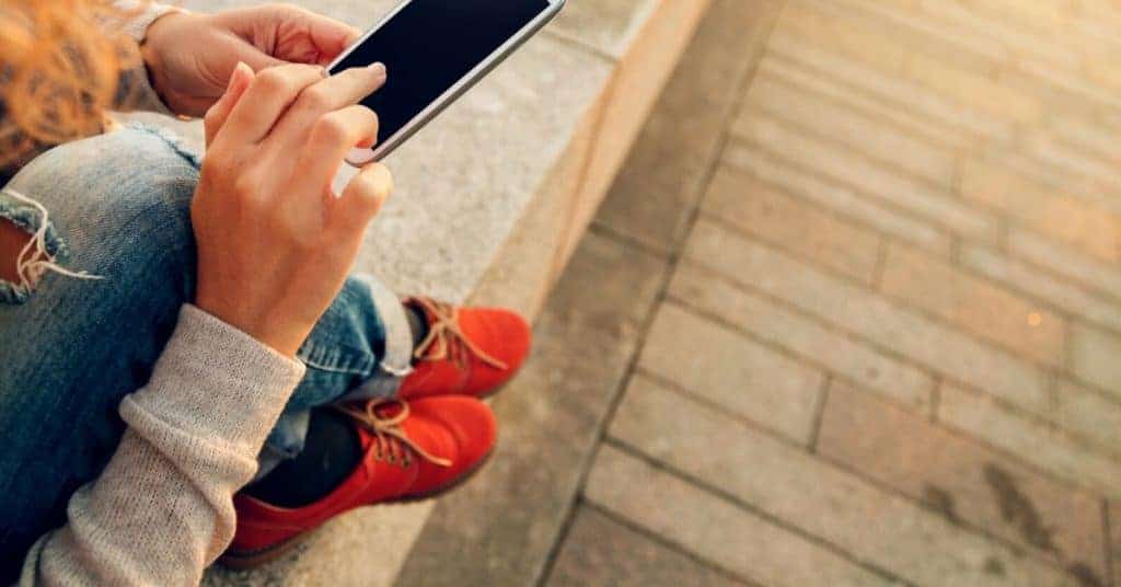 Woman using her smart phone to automate savings