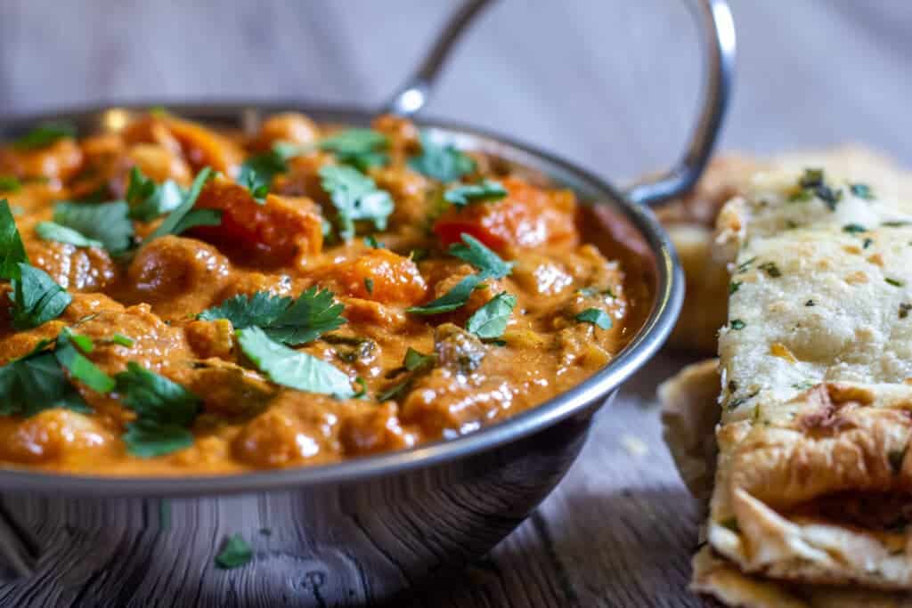 Side view of Slow Cooker and Chickpea Curry with naan bread.