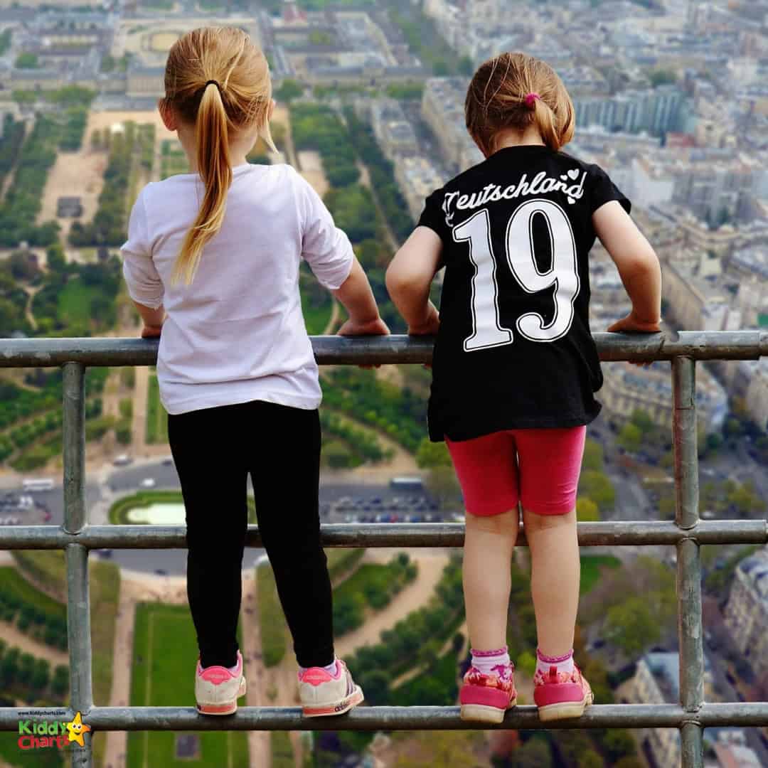 two kids looking down from a balcony