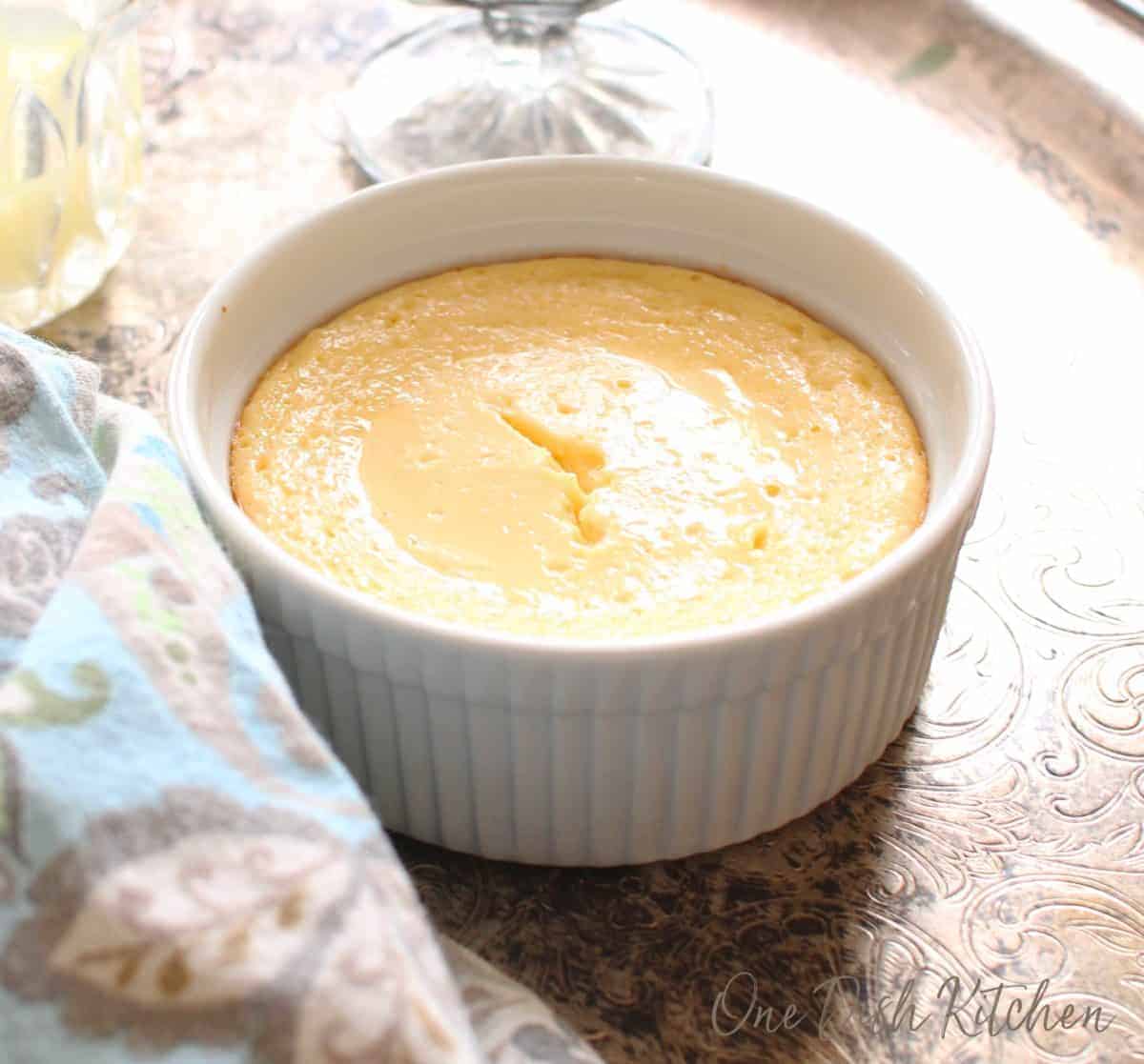 A mini key lime pie in a ramekin on a silver tray.