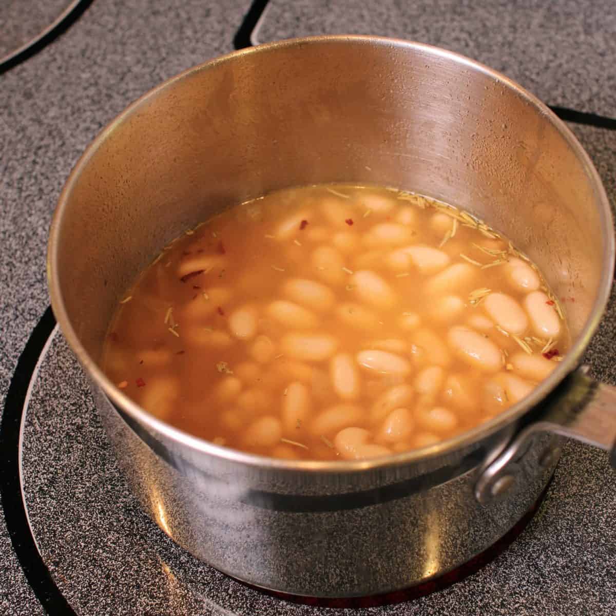 a pot of beans simmering in a broth
