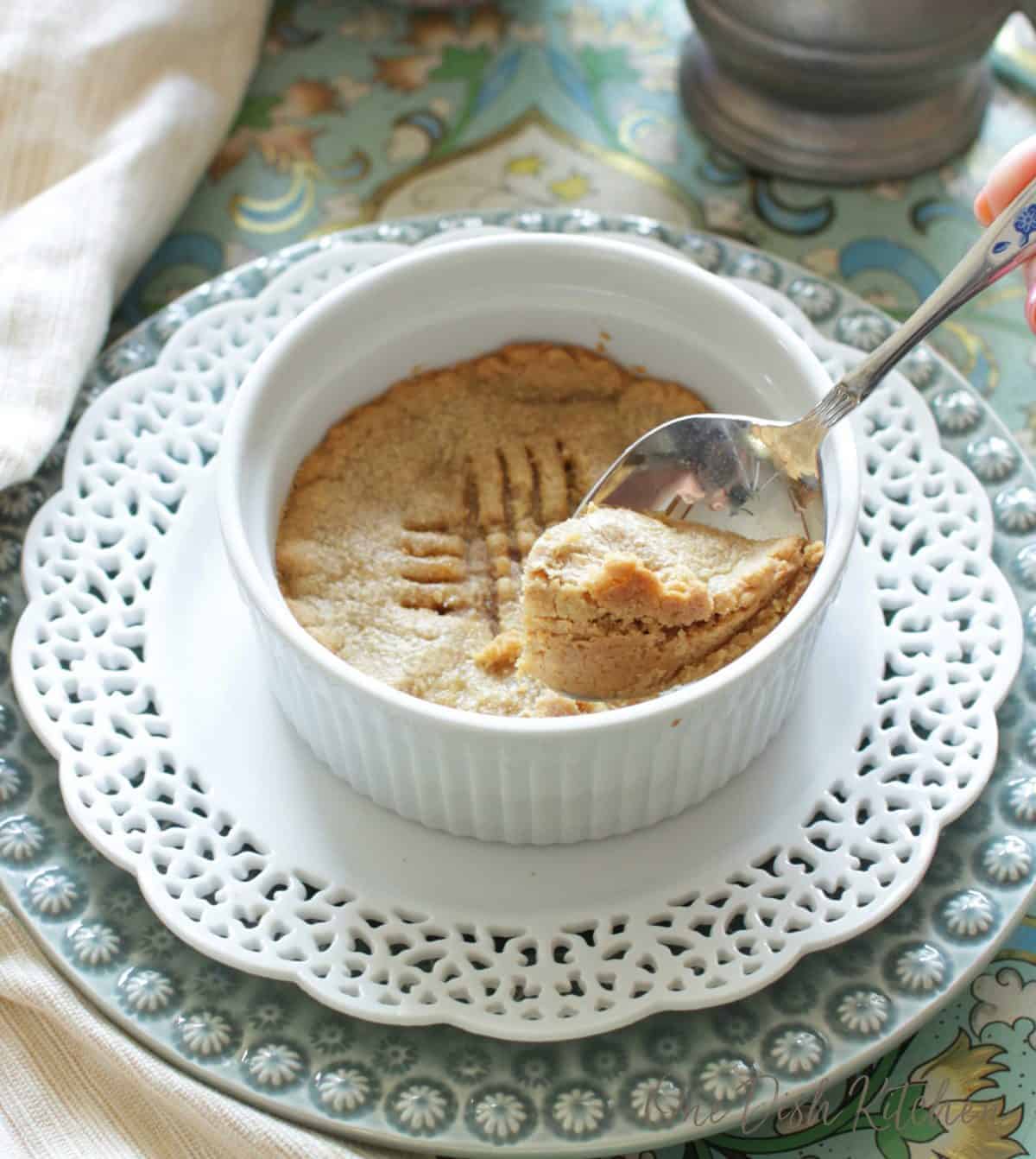 scooping out a spoonful of a cookie from a ramekin.