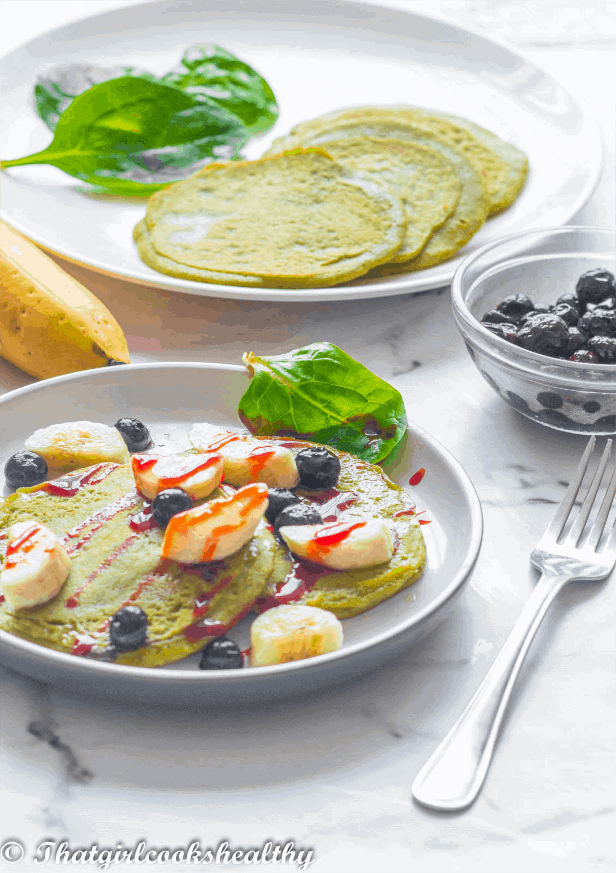 garnished pancakes with banana and blueberries
