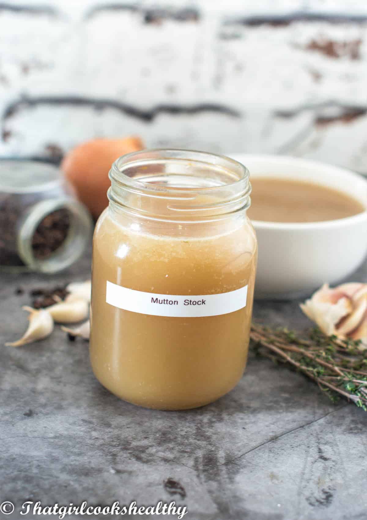 stock in jar with vegetables in background