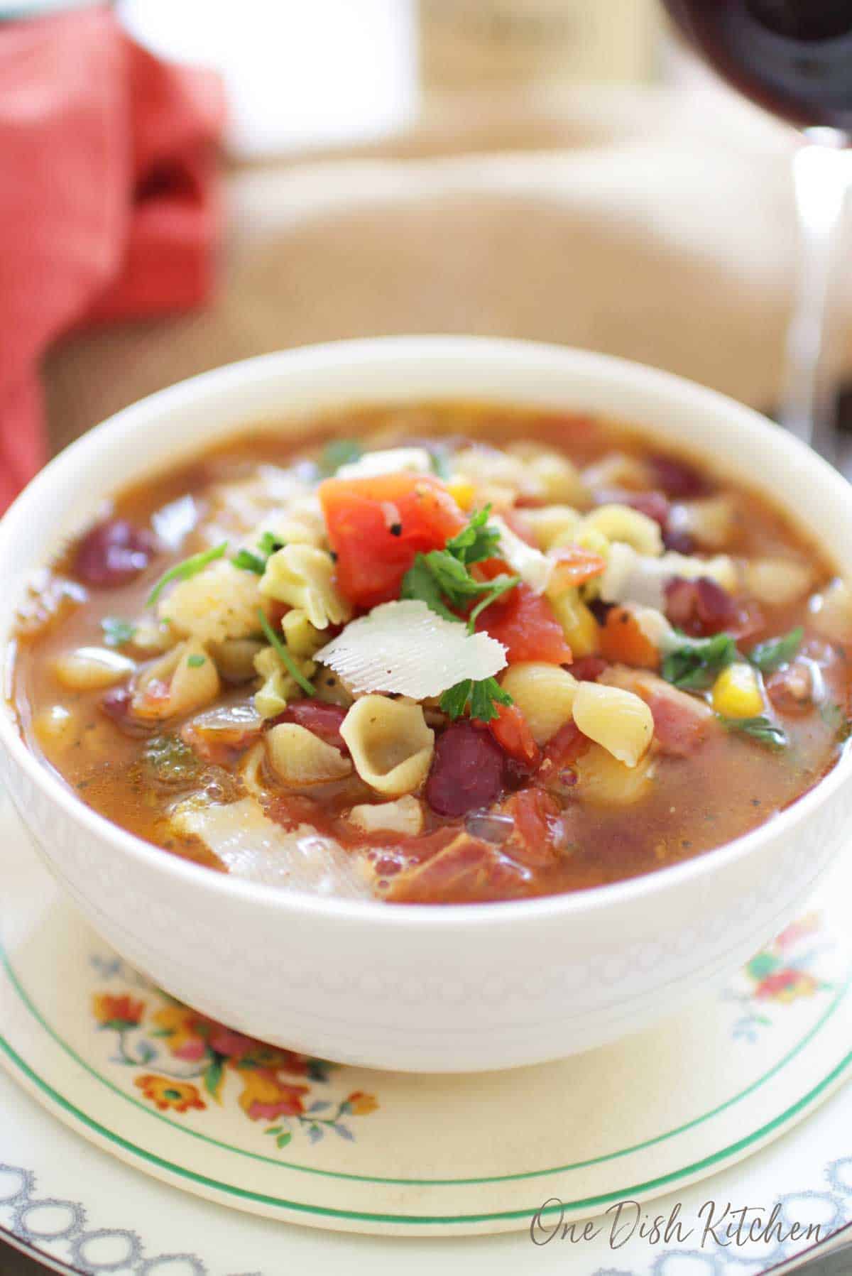 Bowl of minestrone soup topped with shaved parmesan cheese