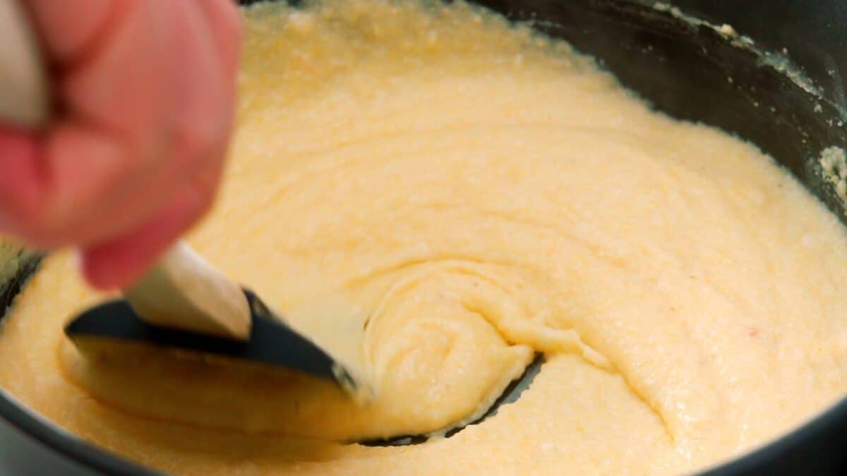 Stirring grits in a large pot.