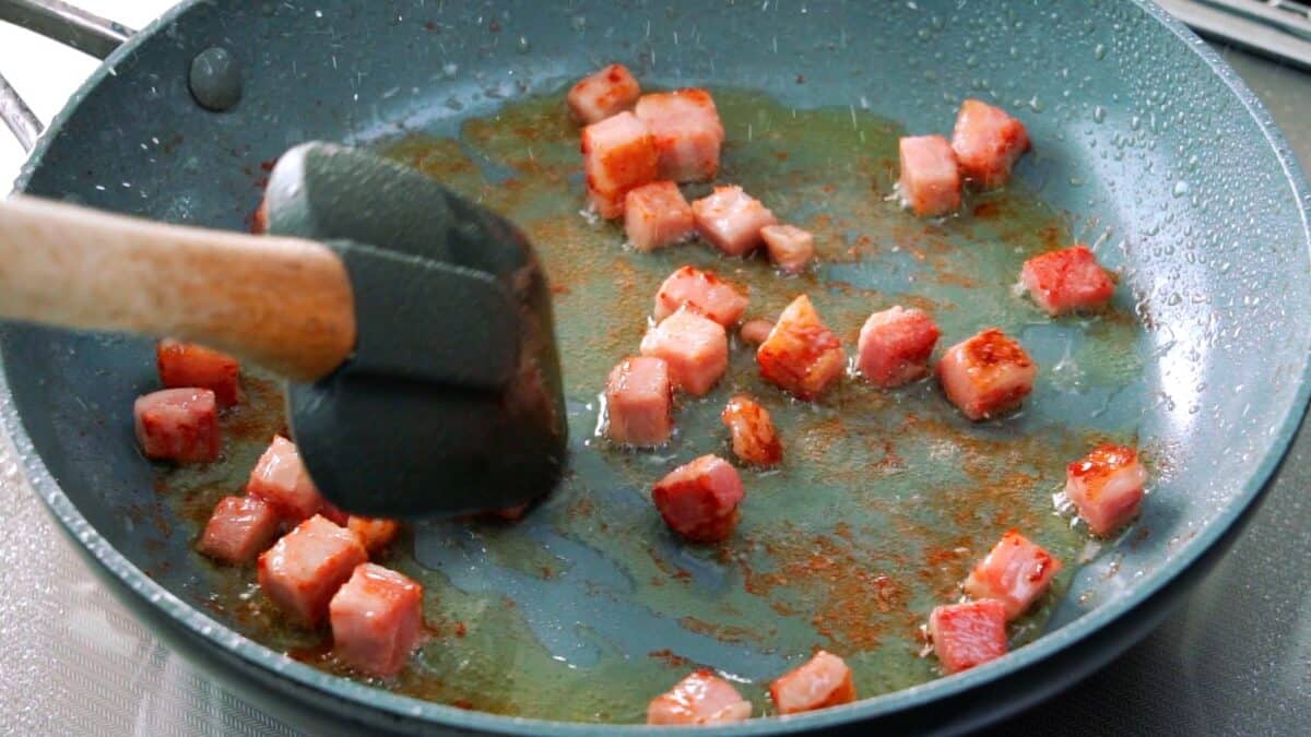 Frying Tasso ham in a frying pan.