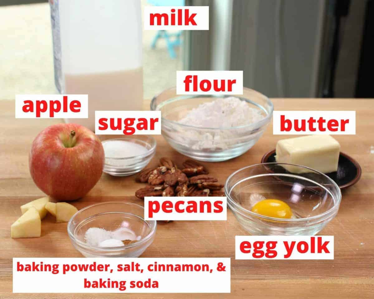 ingredients needed to make apple scones on a brown cutting board.