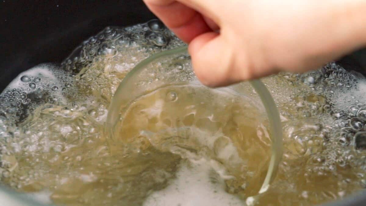 Scooping up some pasta boiling liquid for the sauce.