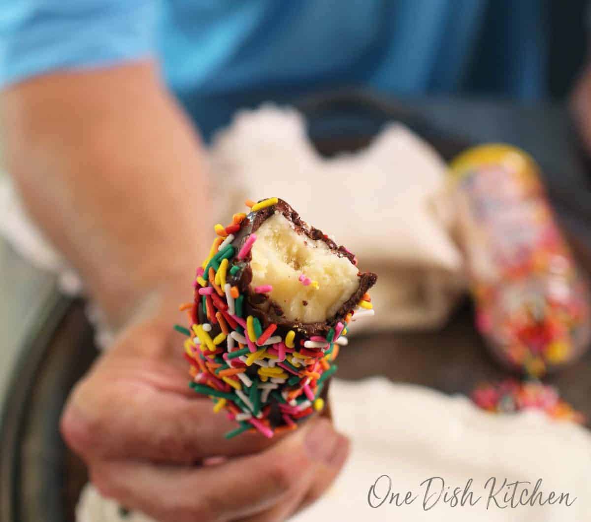 a close up of a frozen banana with a bite taken out.