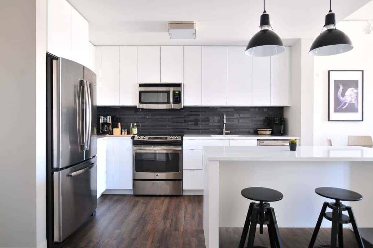 clean and empty white kitchen with stainless appliances