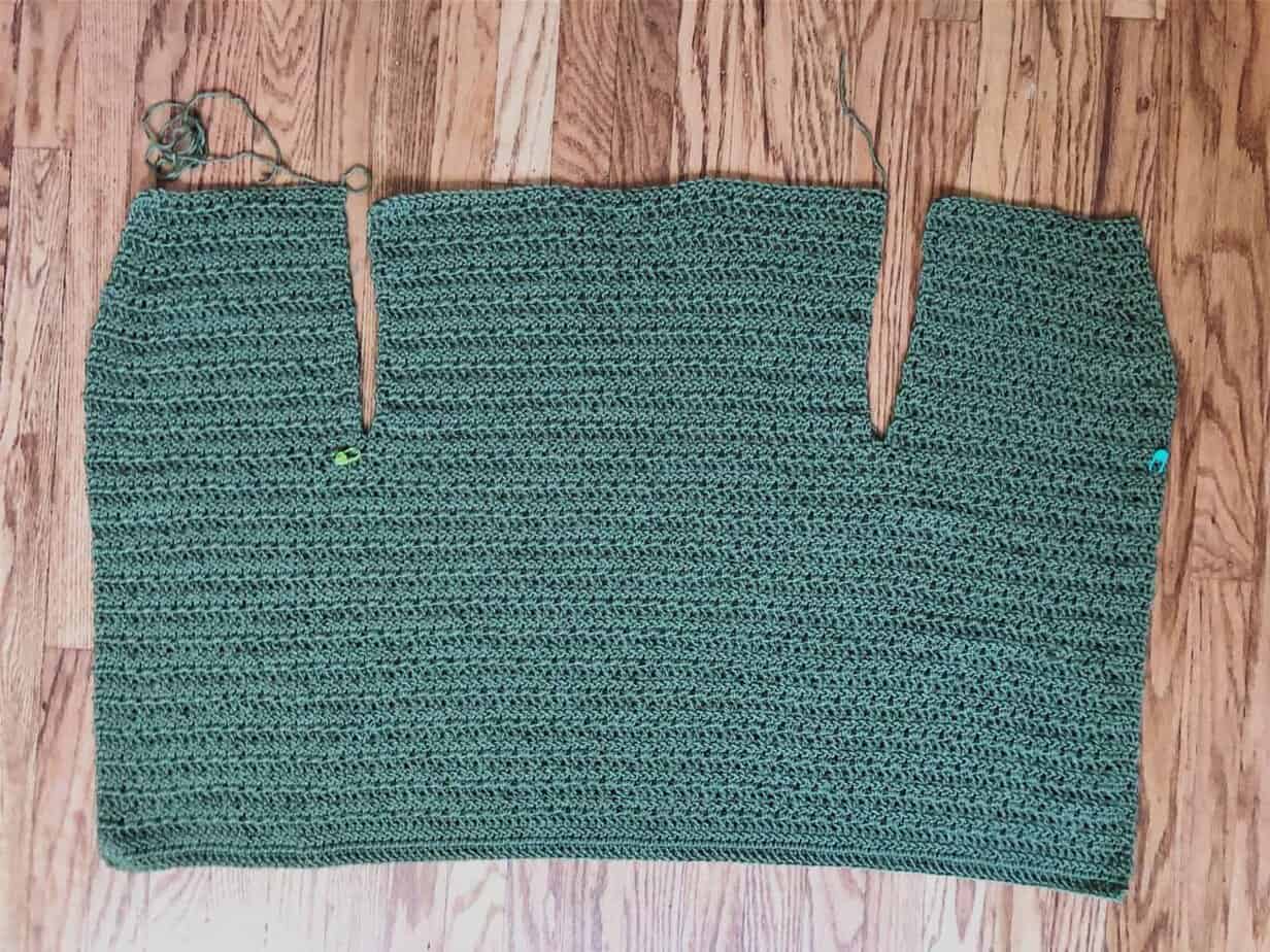 picture of crochet cardigan divided for back and front panels on wood floor